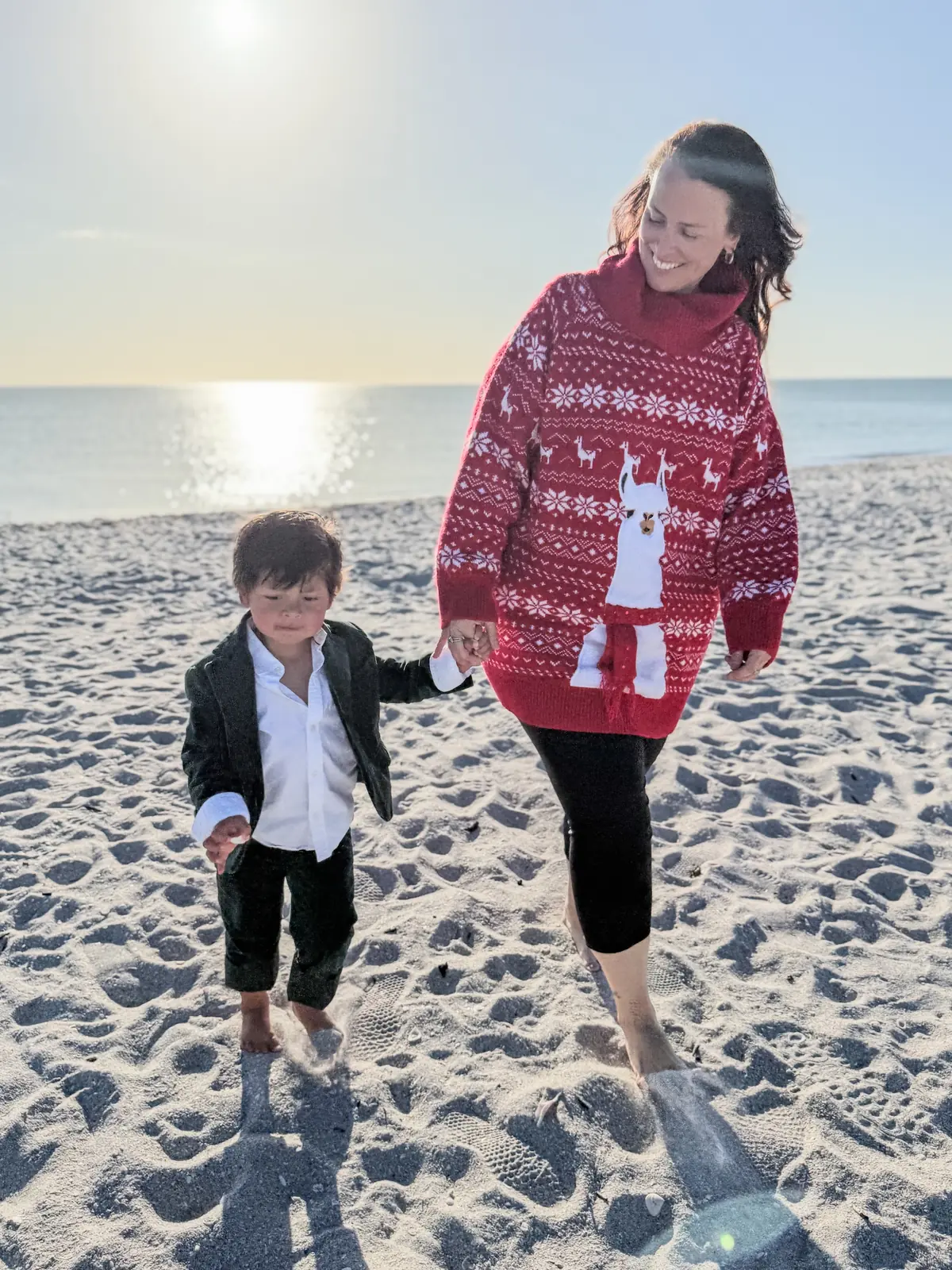 Elissa walking hand in hand with her son along the shoreline