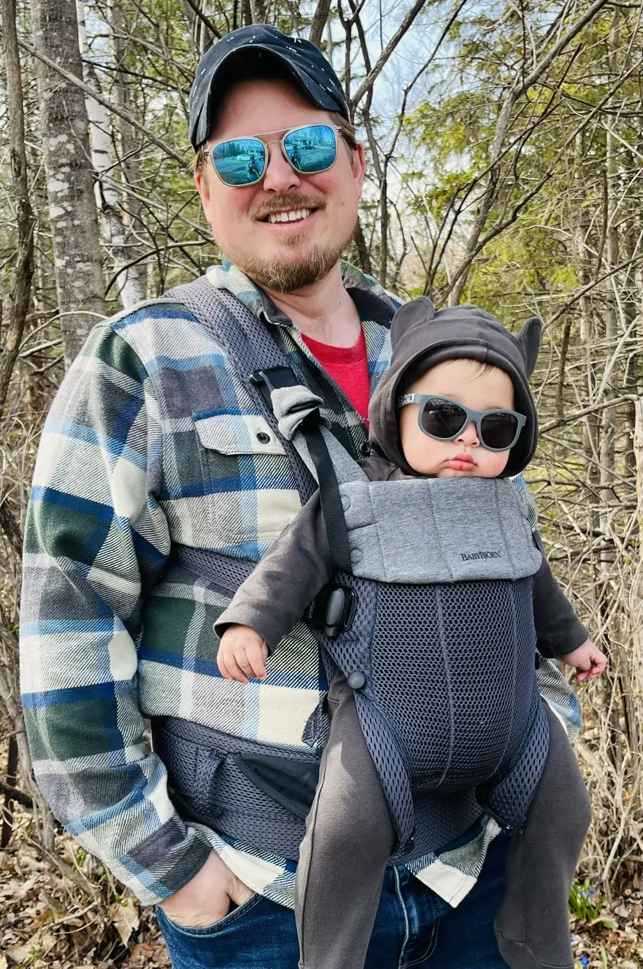 Dad on a wooded trail carrying the baby in a front carrier